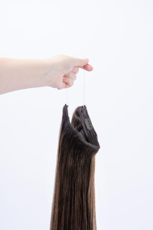 Mousey Brown (#6B) Halo Hair Extensions: hand holding extension by its string